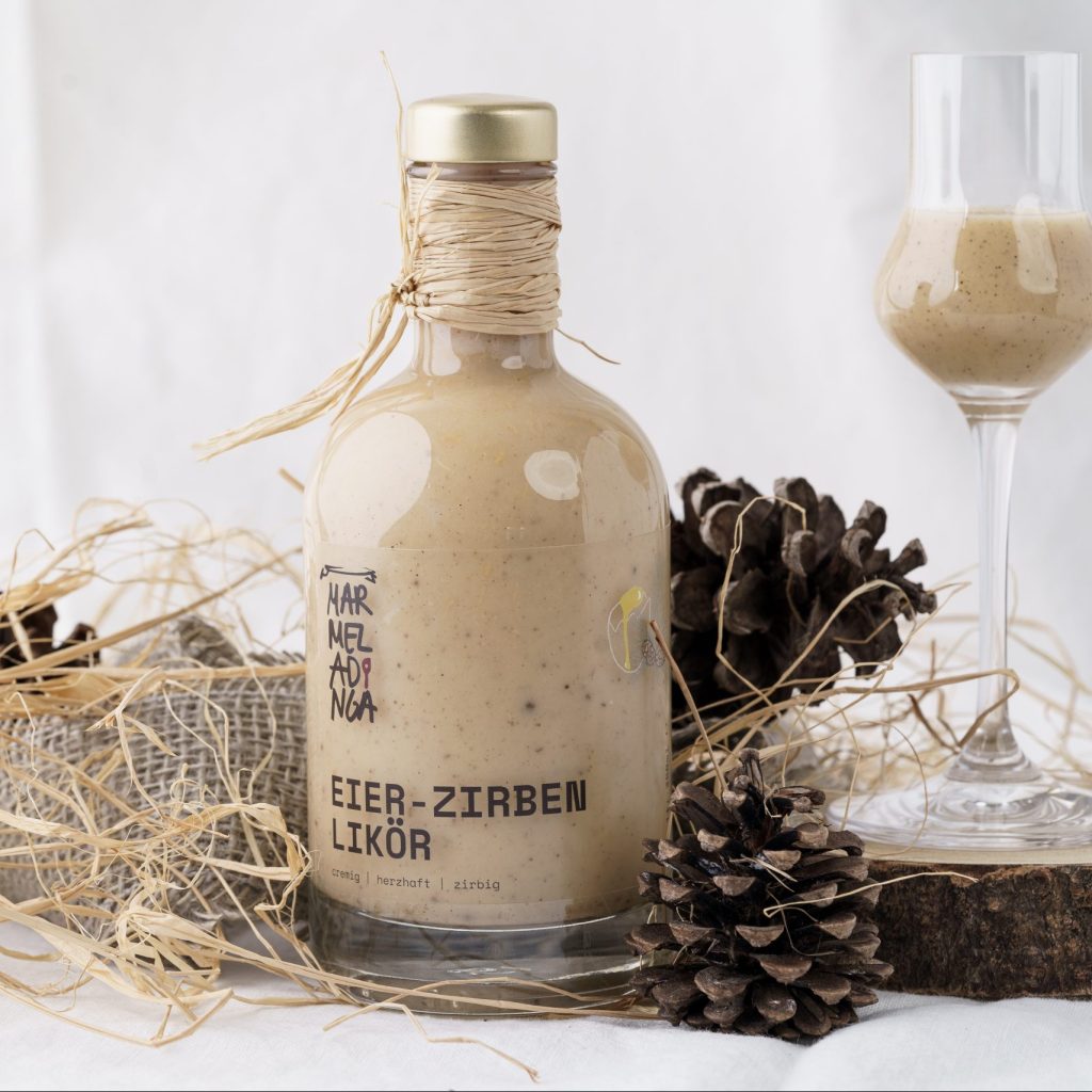 Ein Bil, das eine Flasche Eier-Zirben Likör von Marmeladinga zeigt.